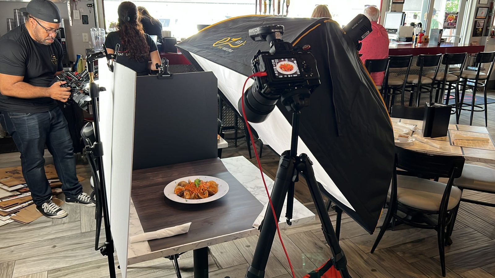 Overhead camera rig filming a pasta dish at the bar