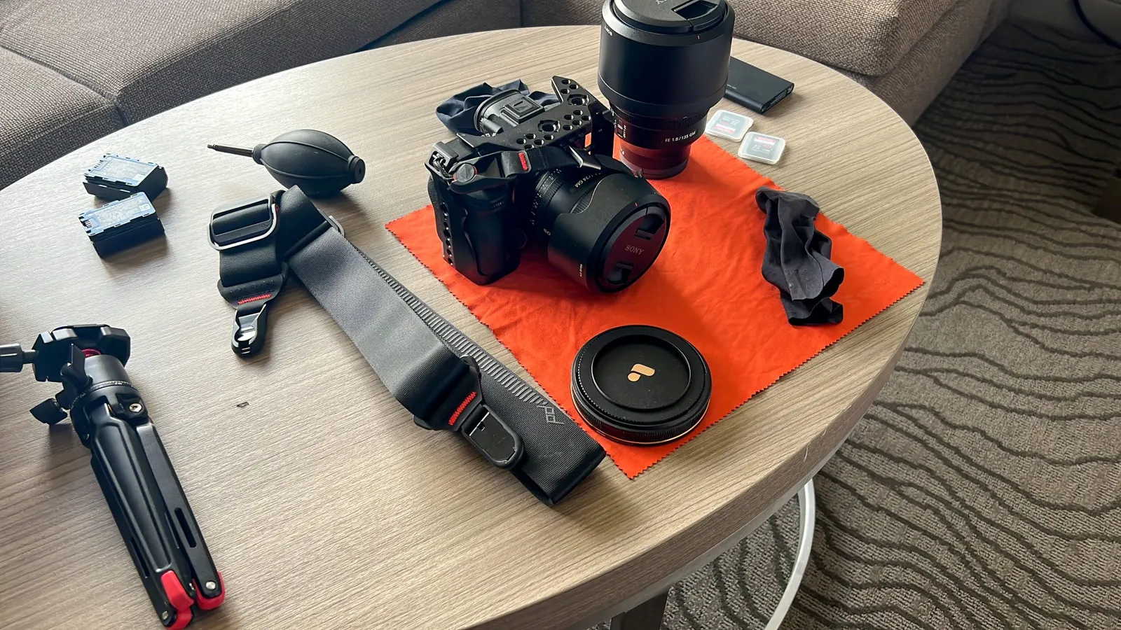A camera, lenses and batteries laid out before a shoot