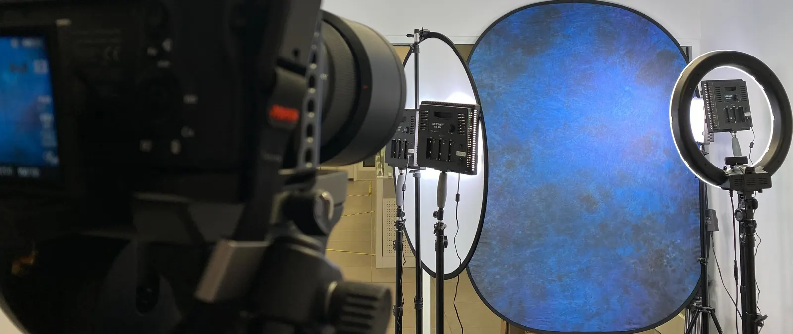 A backdrop and ring light seen past the camera