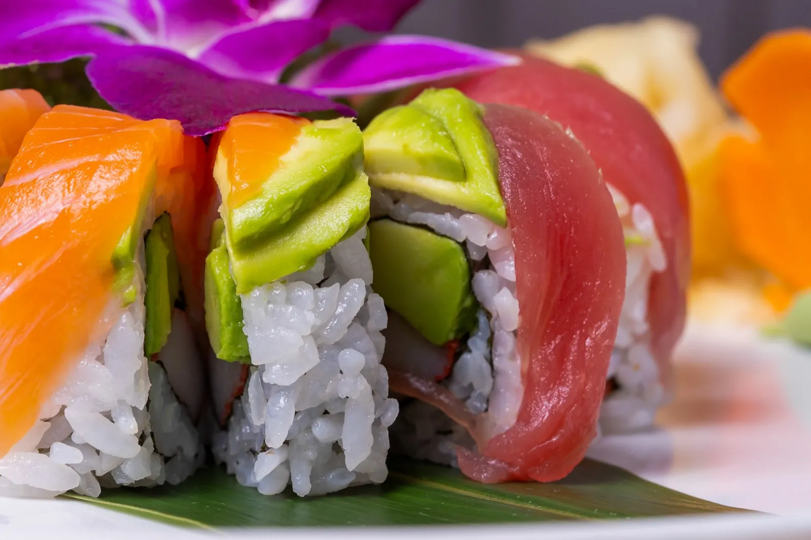 A rainbow roll with salmon, tuna and avocado