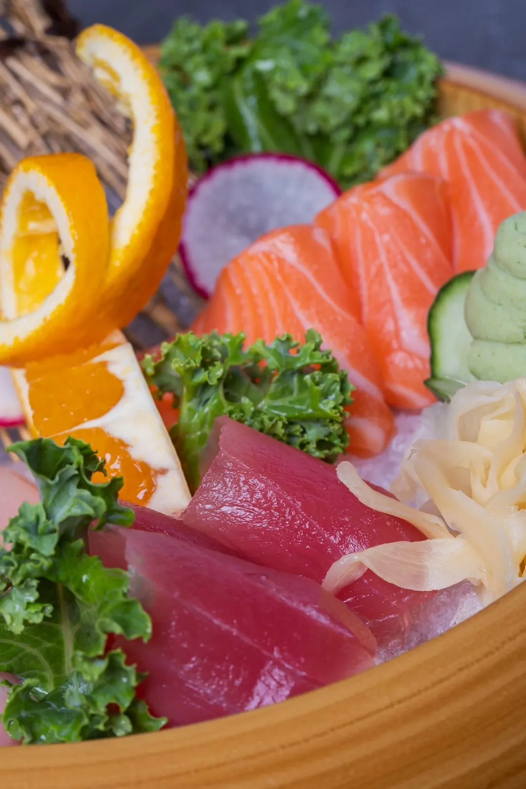 A sashimi platter of tuna, salmon and yellowtail with orange and wasabi
