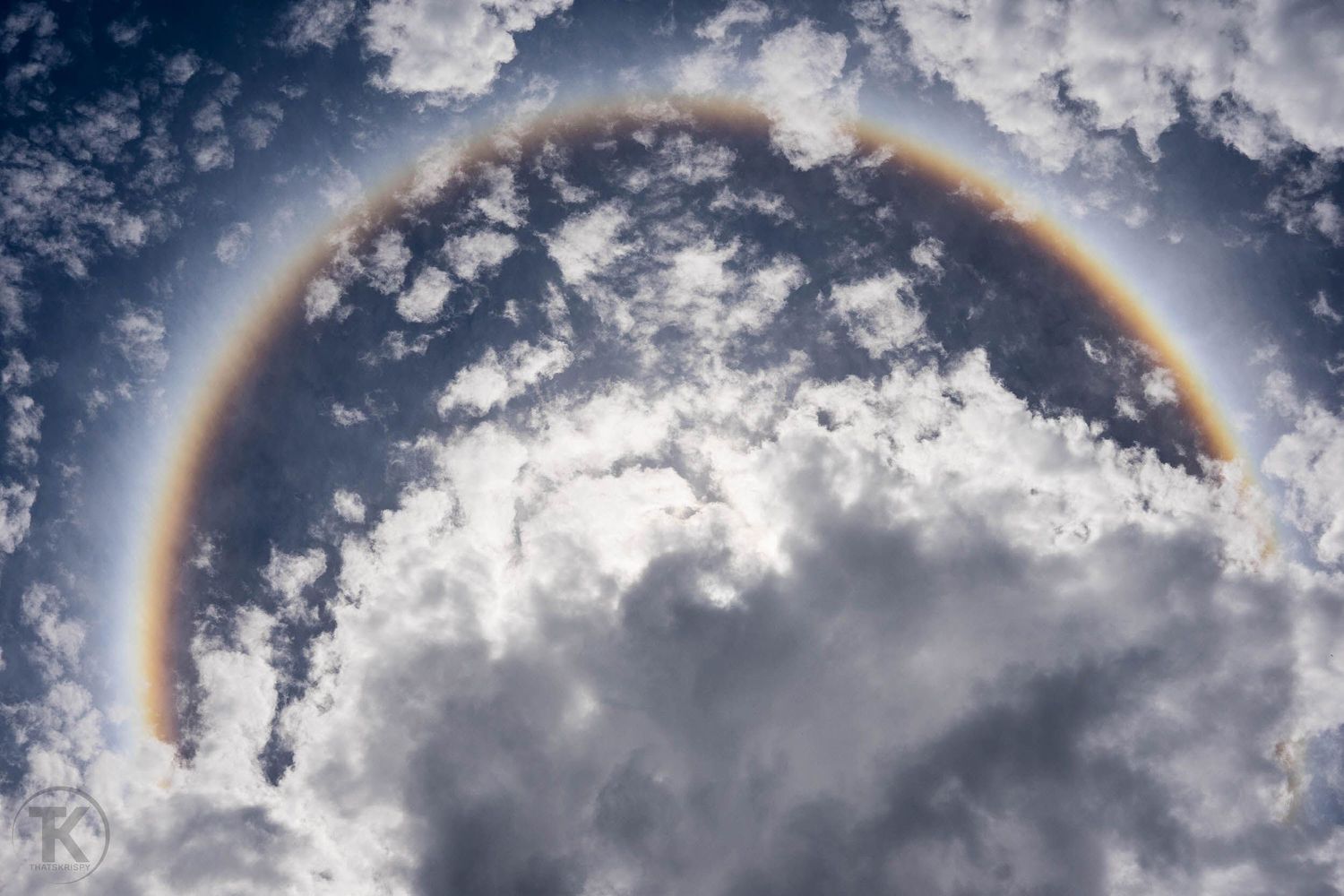 Un halo de arcoíris circular formándose alrededor de las nubes