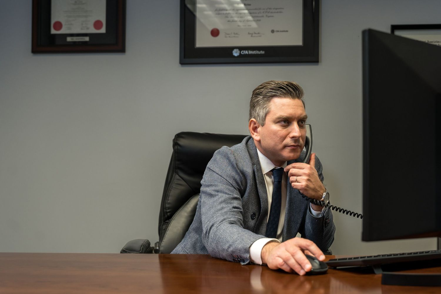Executive on the phone at a dark wood desk