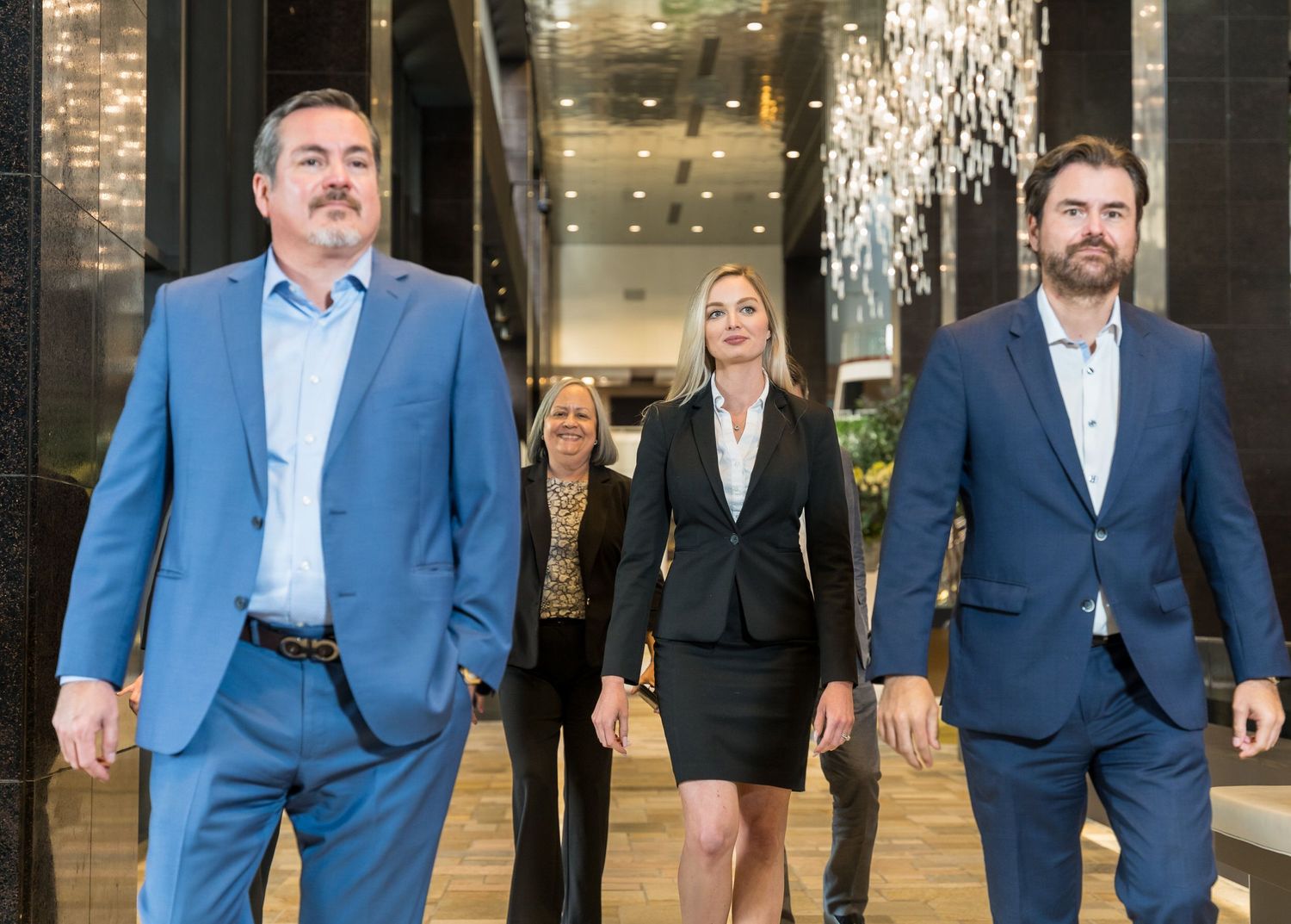 Office team walking together through a marble hallway