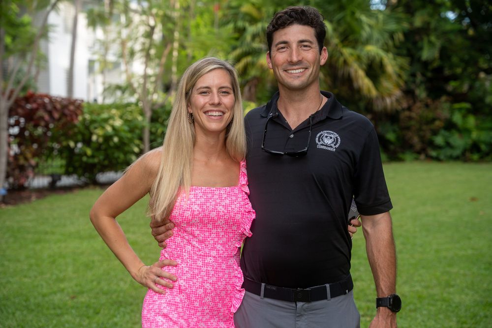 Couple posing together on the lawn at an outdoor evening event