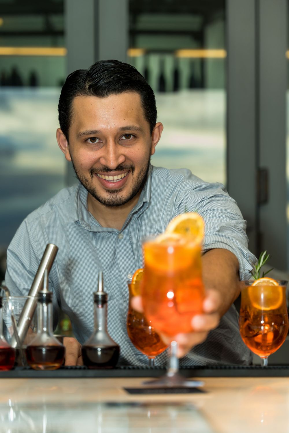 Bartender preparing a cocktail behind the bar at an event