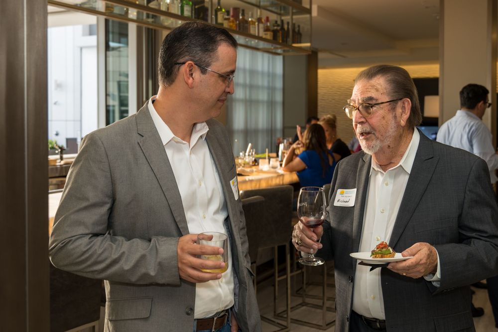 Two guests chatting over drinks at a networking event
