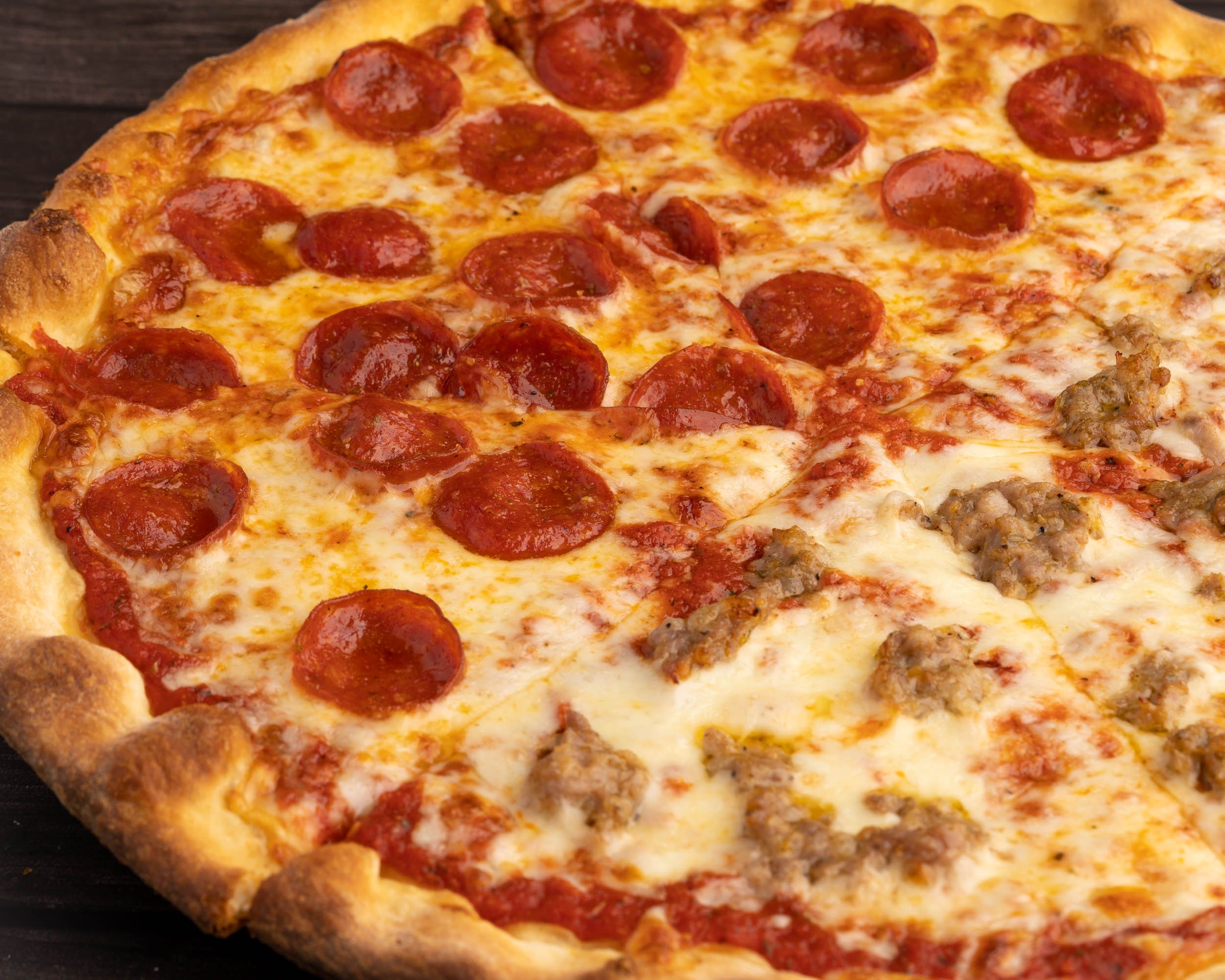 Whole pepperoni pizza on a wood board