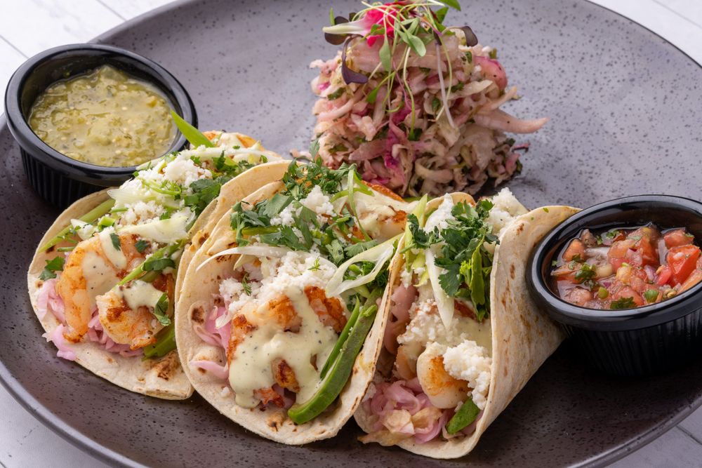 Tres tacos de pescado con salsa y guacamole