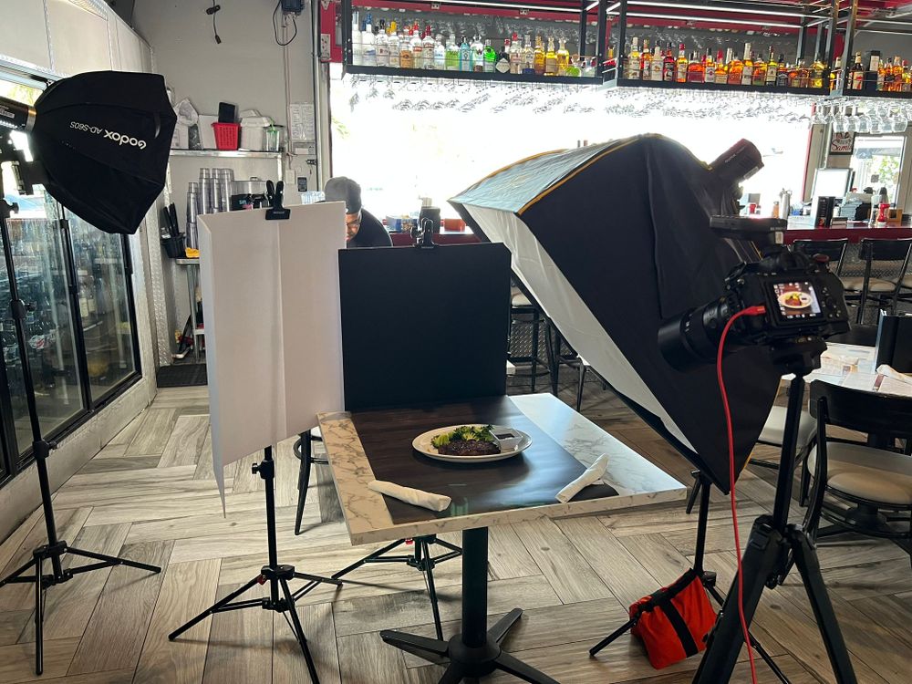 Luces y una cámara alrededor de una mesa de comedor para una sesión combinada de foto y video