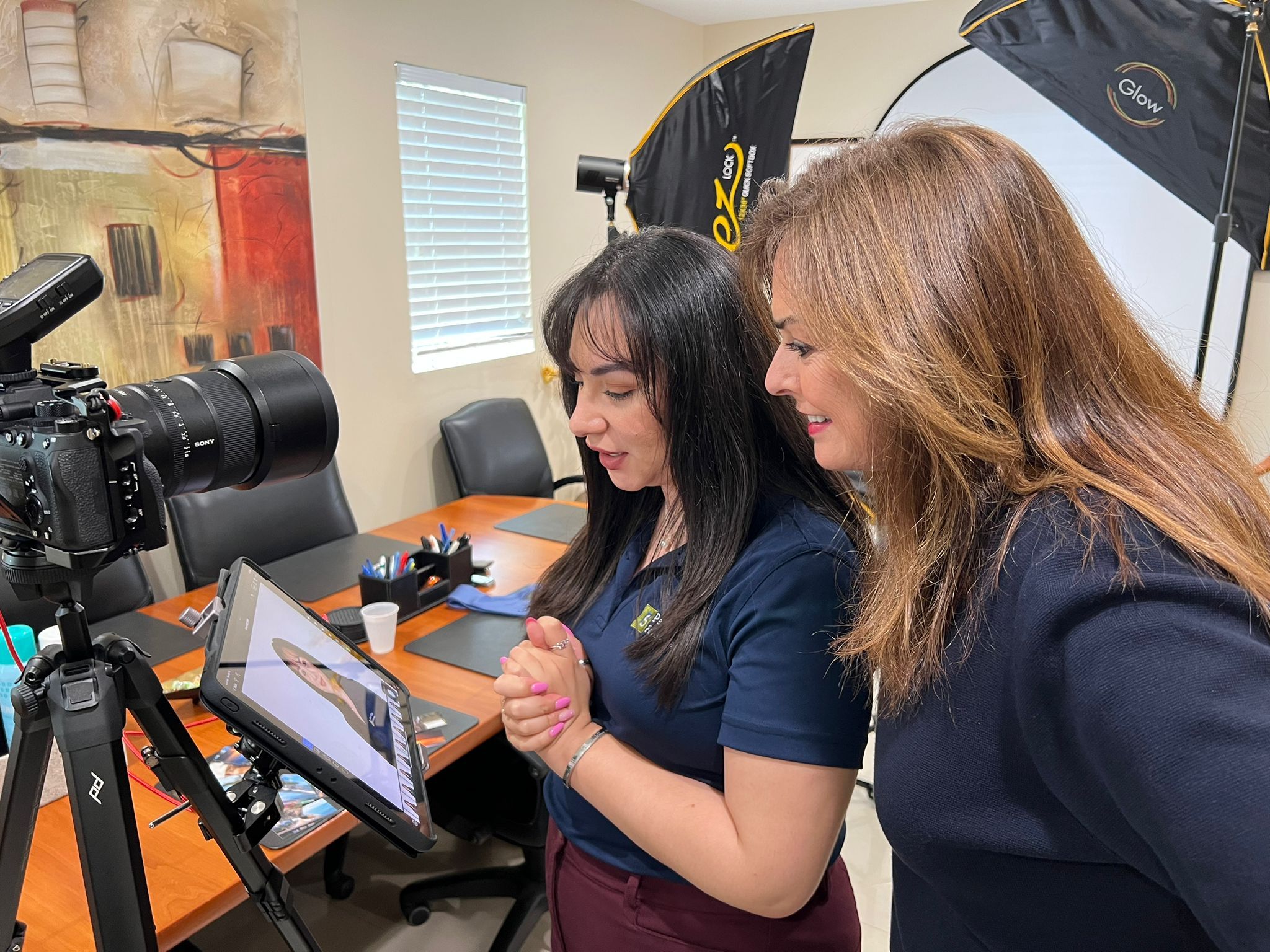 Two people reviewing playback footage on a tablet monitor in an office conference room