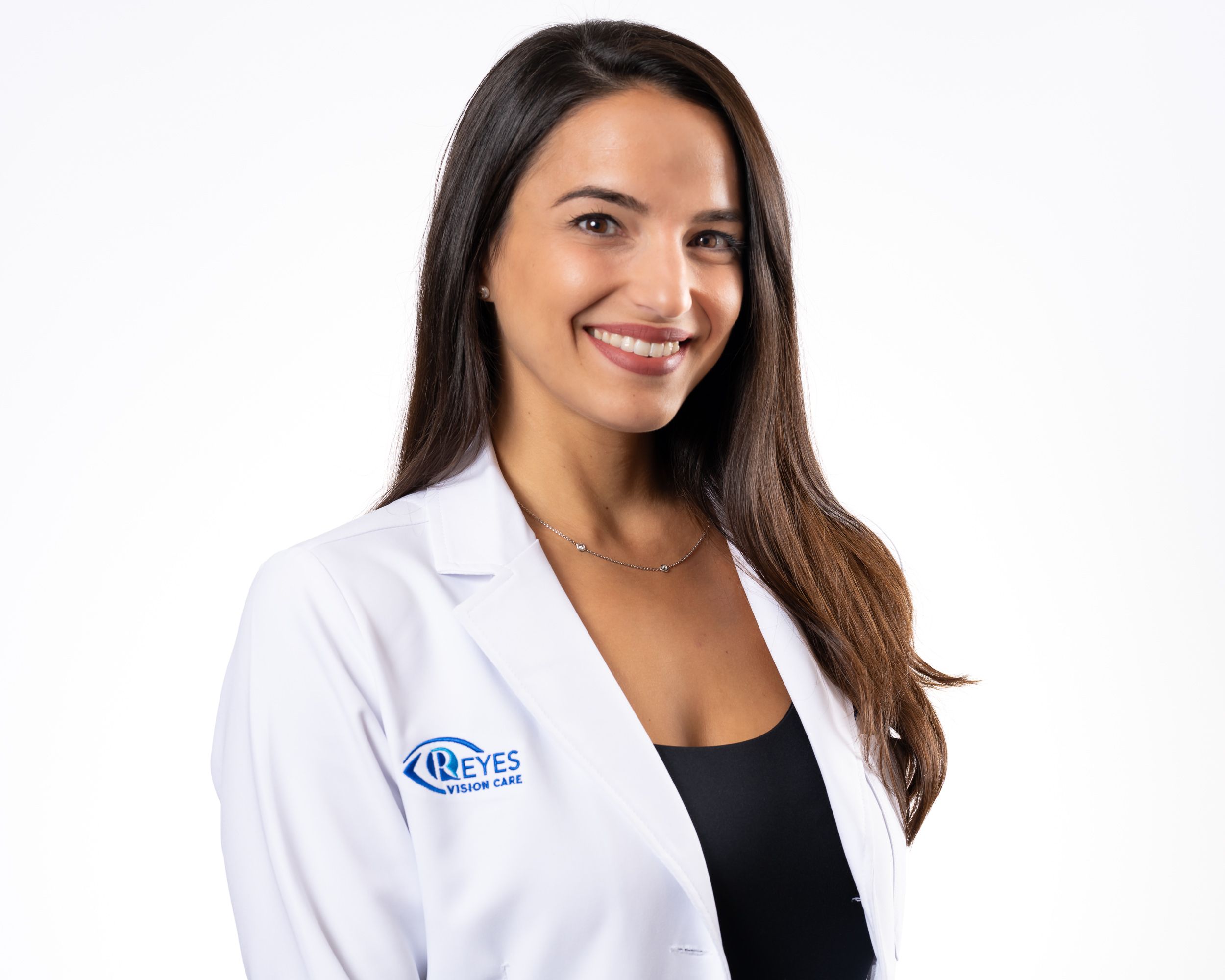 A smiling optometrist in a white coat, studio headshot