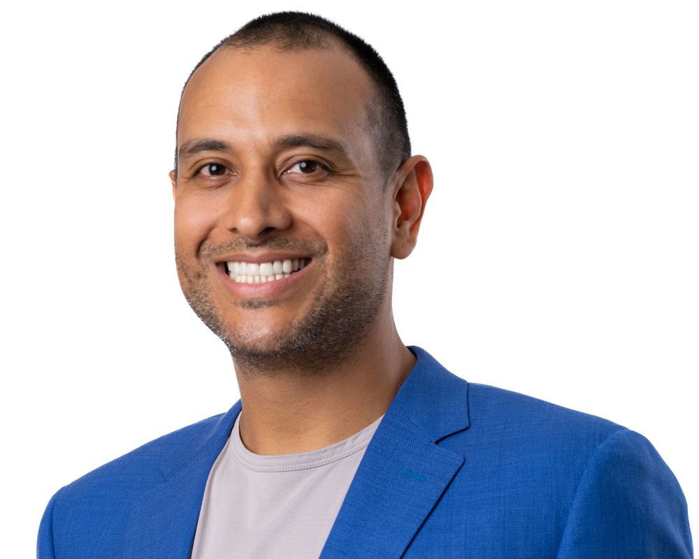 Retrato de estudio sobre fondo blanco, hombre sonriente con blazer azul brillante