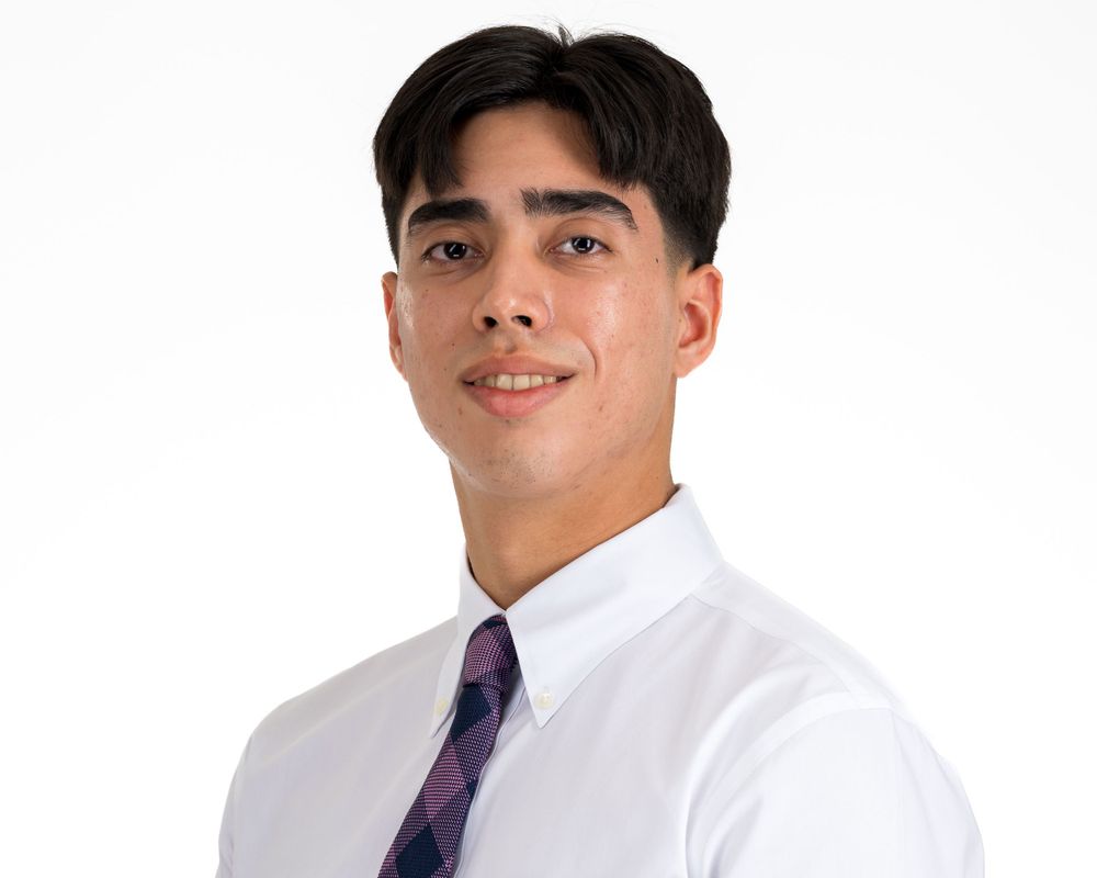 Retrato de estudio sobre fondo blanco, joven con camisa blanca y corbata a cuadros